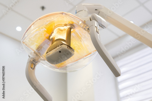 Operating medical light illuminating workplace in bright clinical environment. Professional dental equipment with reflector and handles for precision dentistry in hospital cabinet.
