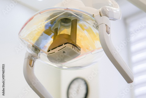 Dental operating light off in modern clinical office. Clean medical cabinet with specialized equipment and reflector before treatment procedure in bright environment.