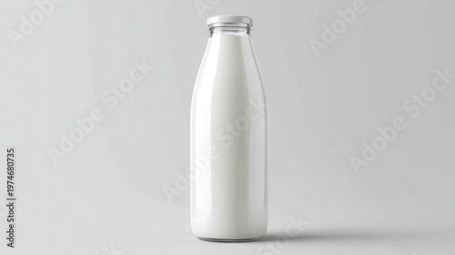 Glass bottle filled with fresh white milk stands isolated against a neutral background.