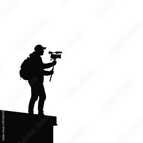 Silhouette of a person filming with a camera on a rooftop