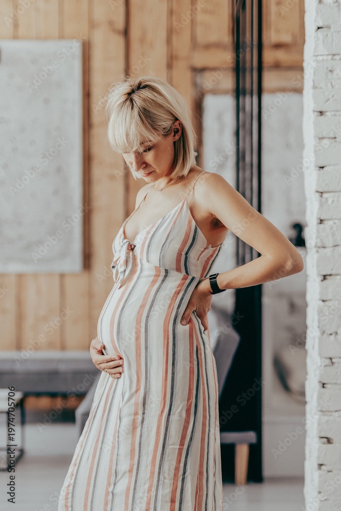 Obraz premium Pregnant blond-haired woman in a living room