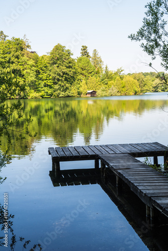Wooden pier overlooking the calm water of Wesslinger See lake in Bavaria, Germany