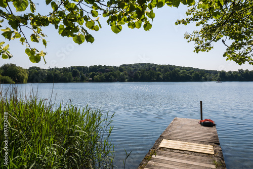 Wooden pier overlooking the calm water of Wesslinger See lake in Bavaria, Germany