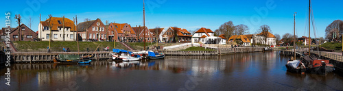 Scenic view of the historic fishing village Carolinensiel in East Frisia with traditional harbor, boats and coastal atmosphere. Peaceful maritime setting under natural daylight.