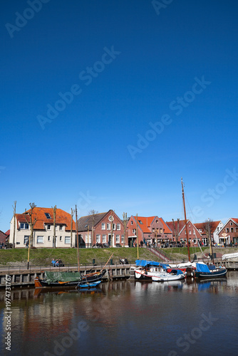 Scenic view of the historic fishing village Carolinensiel in East Frisia with traditional harbor, boats and coastal atmosphere. Peaceful maritime setting under natural daylight.