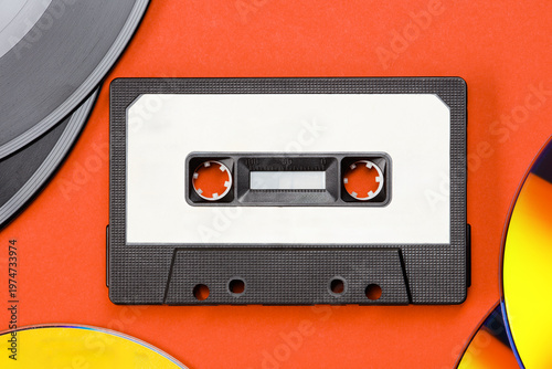 Collection of vinyl records and Audio cassette tape, CD disc on a orange color background. Vintage media concept. Top view.  Retro acoustic. 