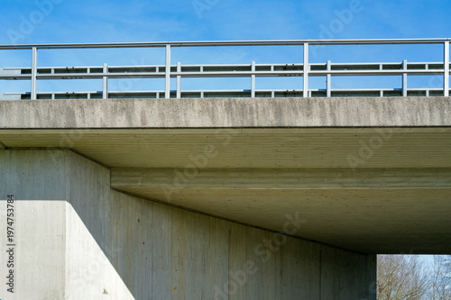 Concrete bridge structure under blue sky with modern railing