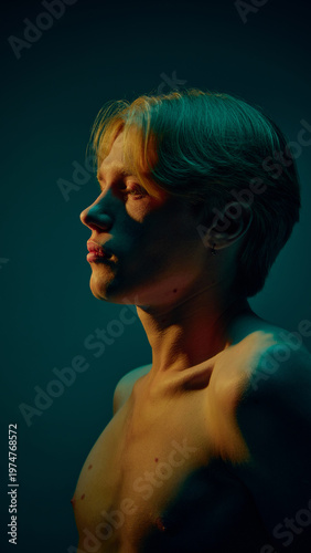 Side profile portrait of young man with clean skin in dramatic colored lighting. Concept of male skincare routine, daily care habits, hydration balance, and modern grooming lifestyle visuals.