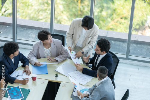 Photos Top view of diverse business team meeting in office, analyzing charts and docume