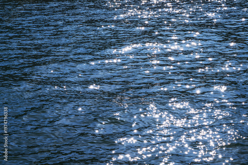 Fotografía Sparkling blue water surface with sunlight reflecting on gentle ripples