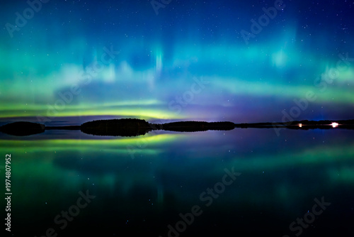 Northern lights dancing over lake in Farnebofjarden national park in north o Sweden