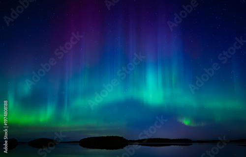 Northern lights dancing over lake in Farnebofjarden national park in north o Sweden