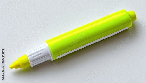 A bright yellow highlighter pen lies on a white surface