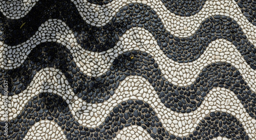 Black and white pebble mosaic pattern with wavy lines. Classic mediterranean design and abstract texture for background.