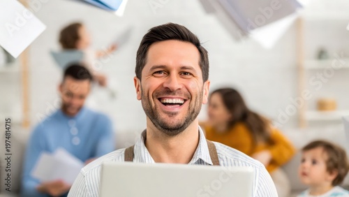 Father Day Smiling man using laptop at home with family blurred in the background, suggesting work-life balance and happiness.