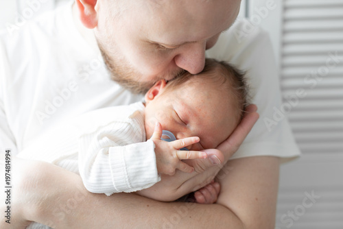 Fényképezés Close-up of a newborn baby sleeping peacefully in the arms of a parent wearing a white shirt