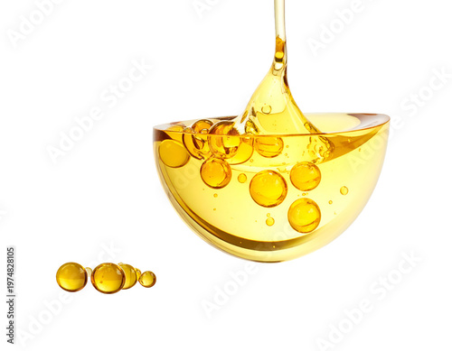 Golden liquid pouring into a clear bowl with pearls