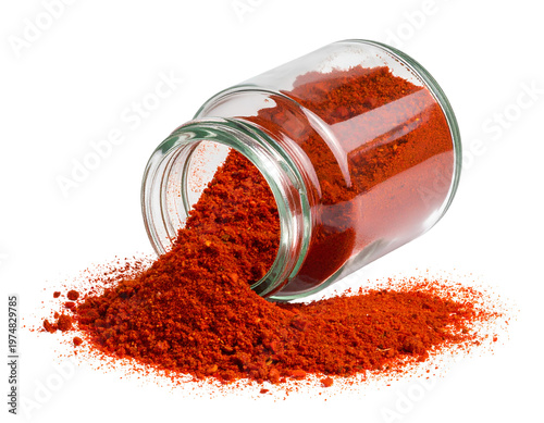Glass jar tipped over, spilling vibrant red powder onto white