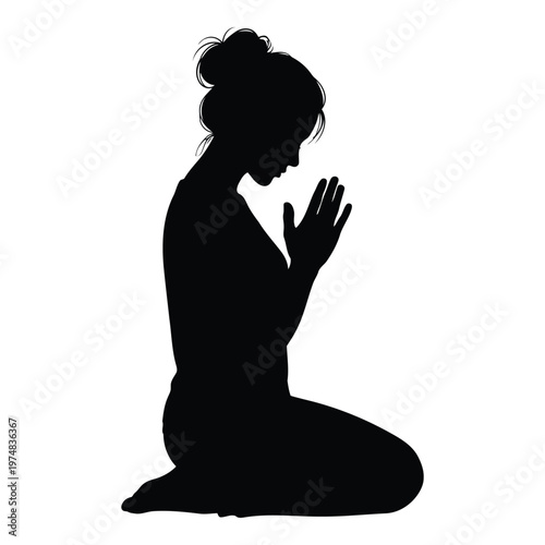 Silhouette of a woman praying on her knees with her hands together in a gesture of worship or supplication 