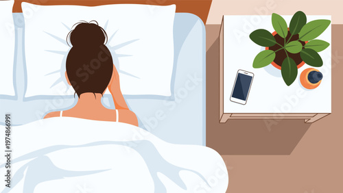 Woman lying in bed at night looking at her smartphone while a plant and water sit on the bedside table next to her.