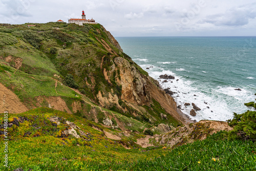 Cabo da Roca dramatic coastal cliff overlooking Atlantic Ocean in Portugal. Scenic westernmost point of Europe with rugged landscape, ocean waves and natural coastline.