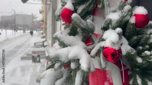 A Christmas wreath in the snow, beautiful bright winter decorations on shop windows. Snowfall on the city streets. The city is buried in snow. Ternopil, Ukraine