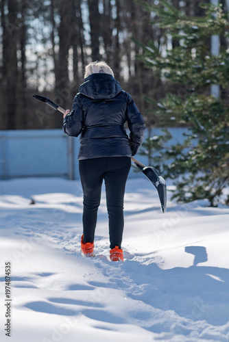 A woman heads out to clear snow.