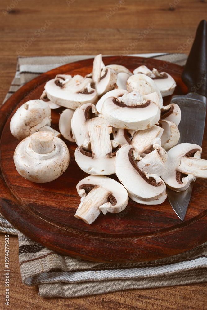 Fototapeta premium fresh mushrooms, chopped, in a wooden bowl, whole, top view, no people,