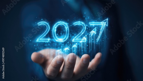 Digital projection of glowing 2027 with rising arrows over hand