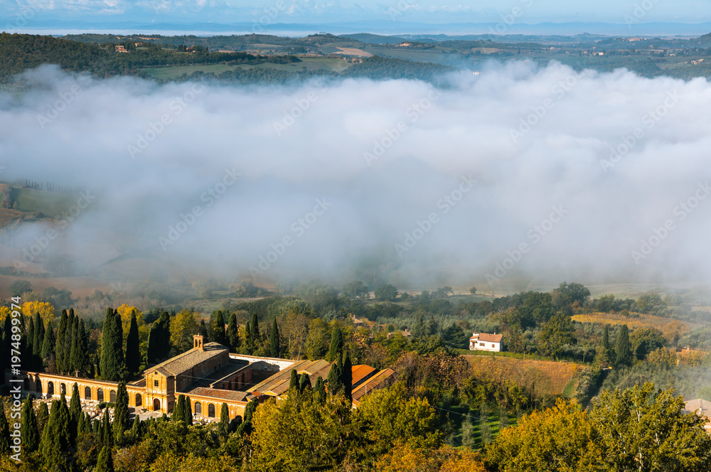 Obraz premium Fog rolling through valley with buildings in Montepulciano, Italy.