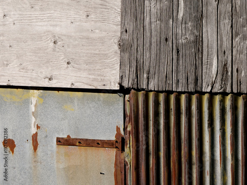 Detail of a shed wall covered in rusty sheet metal and old wooden planks
