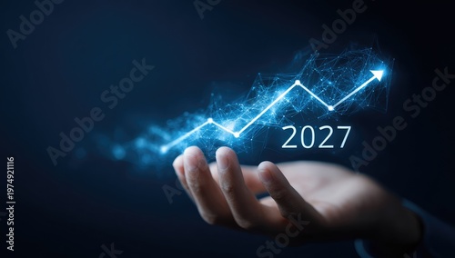 Hand holding glowing digital upward trend graph for year 2027
