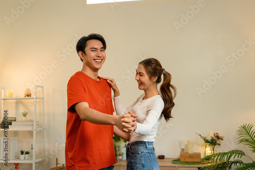 Loving Couple Holding Hands and Dancing at Home
