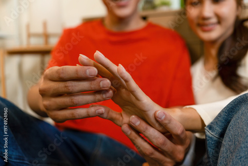 Couple Sitting on Floor Holding Hands at Home