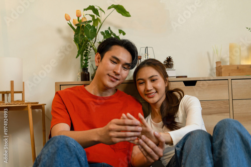Couple Sitting on Floor Holding Hands at Home