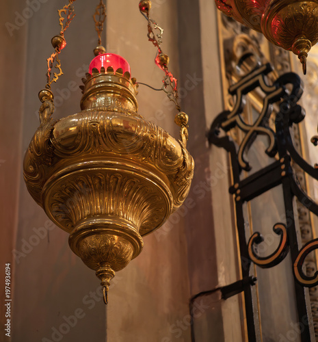 Votive lamp hanging in church, creating a spiritual atmosphere. Ornate votive lamp illuminates a church, symbolizing faith, hope, and devotion in a sacred space