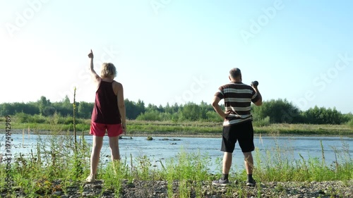 Man and woman doing physical exercises in nature. Healthy lifestyle.