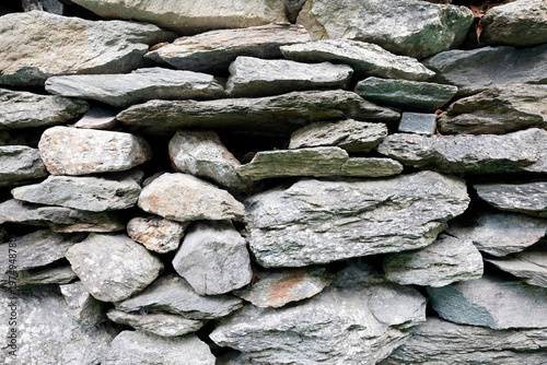Traditional dry-stone masonry wall showcasing natural alpine granite and schist textures in close detail. Saint Gervais.  France.