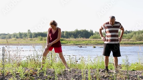Man and woman doing physical exercises in nature. Healthy lifestyle.