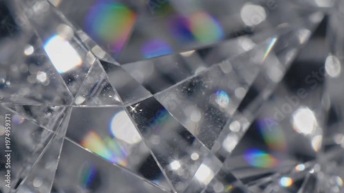 A close up view of a faceted glass surface showing bright light reflections and colorful spectral dispersion patterns