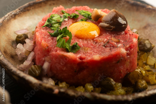 Beef Steak Tartare with Quail Egg on Handmade Ceramic Plate