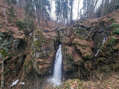 Wilczki Waterfall in Międzygórze, wild mountain landscape with flowing water, rocks and forest gorge, natural beauty and power of nature.