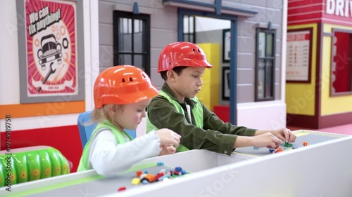 Children in helmets playing with toy colorful blocks of the children room. Kindergarten educational games. Slow motion