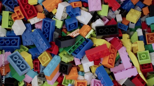 Pile of child building blocks in multiple colours. Top view. Slow motion. Educational gaming center