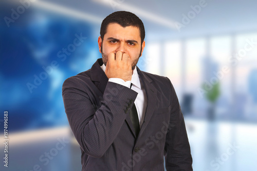 Man in suit covers nose, showing disgust