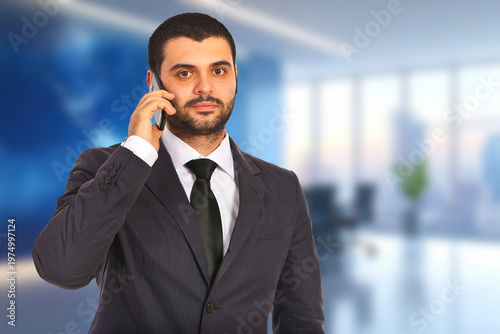 Man in suit talks on phone with serious expression