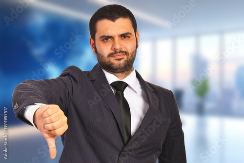 Dressed sharply, man gestures disapproval with a downward thumb