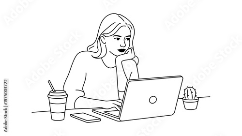 A focused young woman intently works on her laptop with a drink and smartphone nearby.