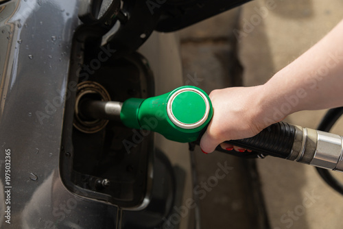 Fotografie Closeup of woman pumping gasoline fuel in car at gas station