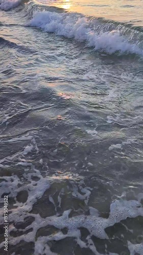 Sunset or dawn in sea. Sundown or sunrise on the ocean. A sunny path on the sea waves. Sun, sky, clouds, sea, sea waves, sandy shore, beach. Morning and evening on coast. Vertical